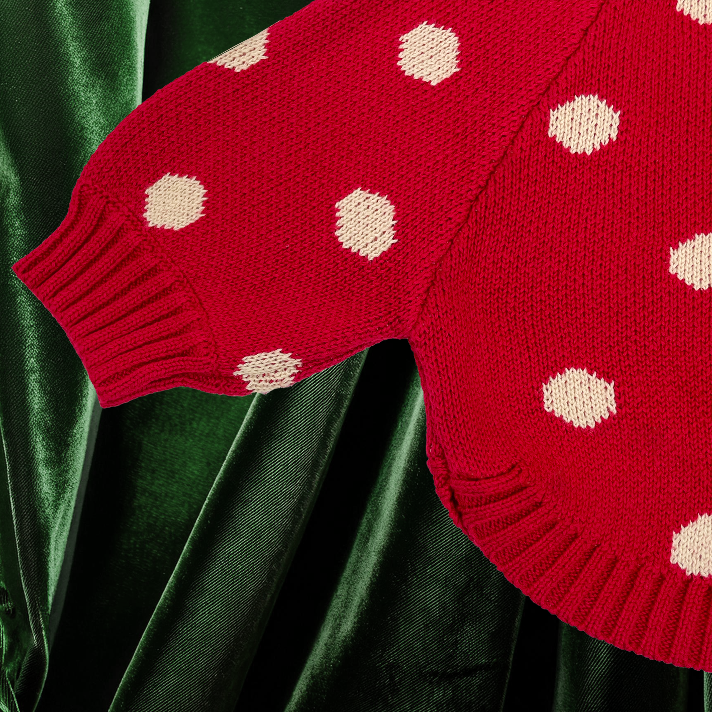 A close up of the red knit jumbo spot baby jumper to show rib cuff and curved hem detail