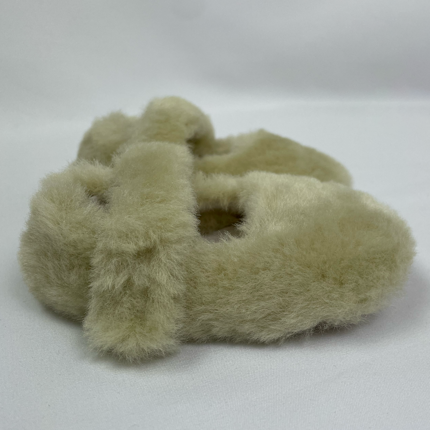 green fluffy baby slippers side view shows fluffy ankle straps with velcro closure
