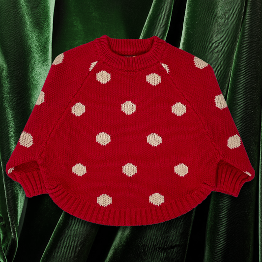 Red knitted oversized baby jumper with beige jumbo spot pattern. Front view shows crew neckline